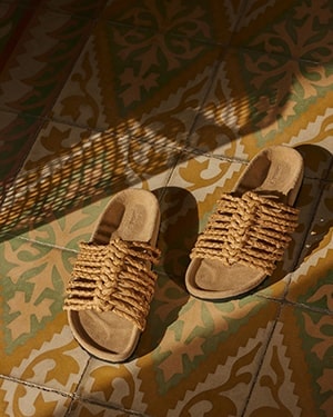 Textured sandals on patterned tile floor