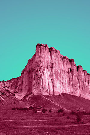 Jagged mountain cliff with streaks of magenta and teal